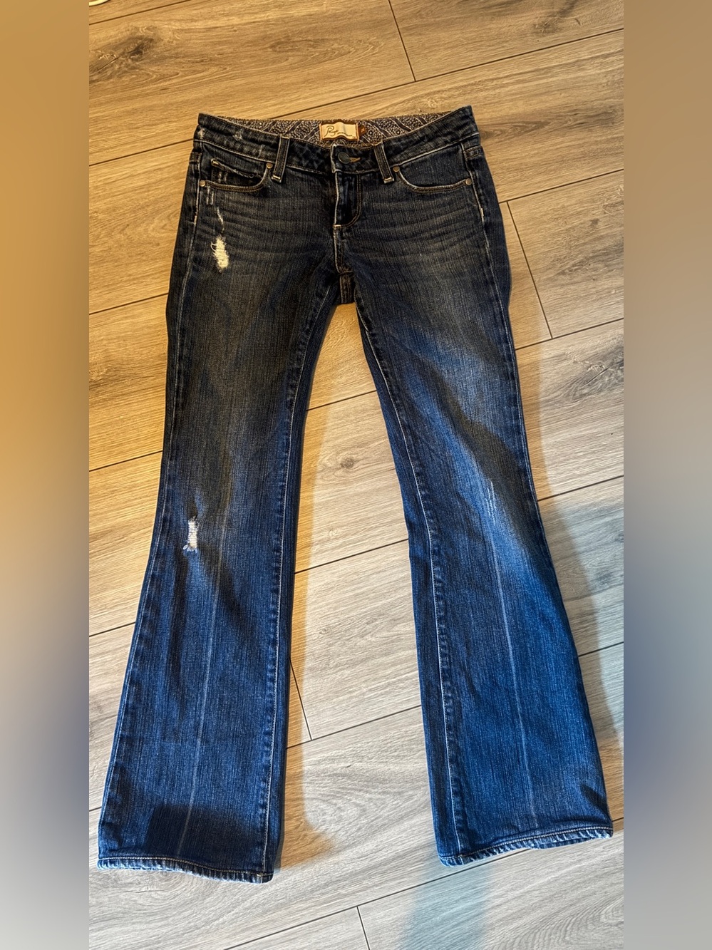 Paige Laurel Canyon distressed low-rise flare jeans in a dark blue wash